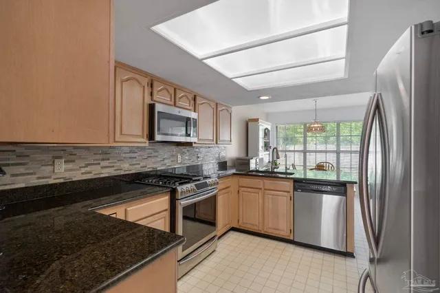 a kitchen with stainless steel appliances a sink stove and cabinets
