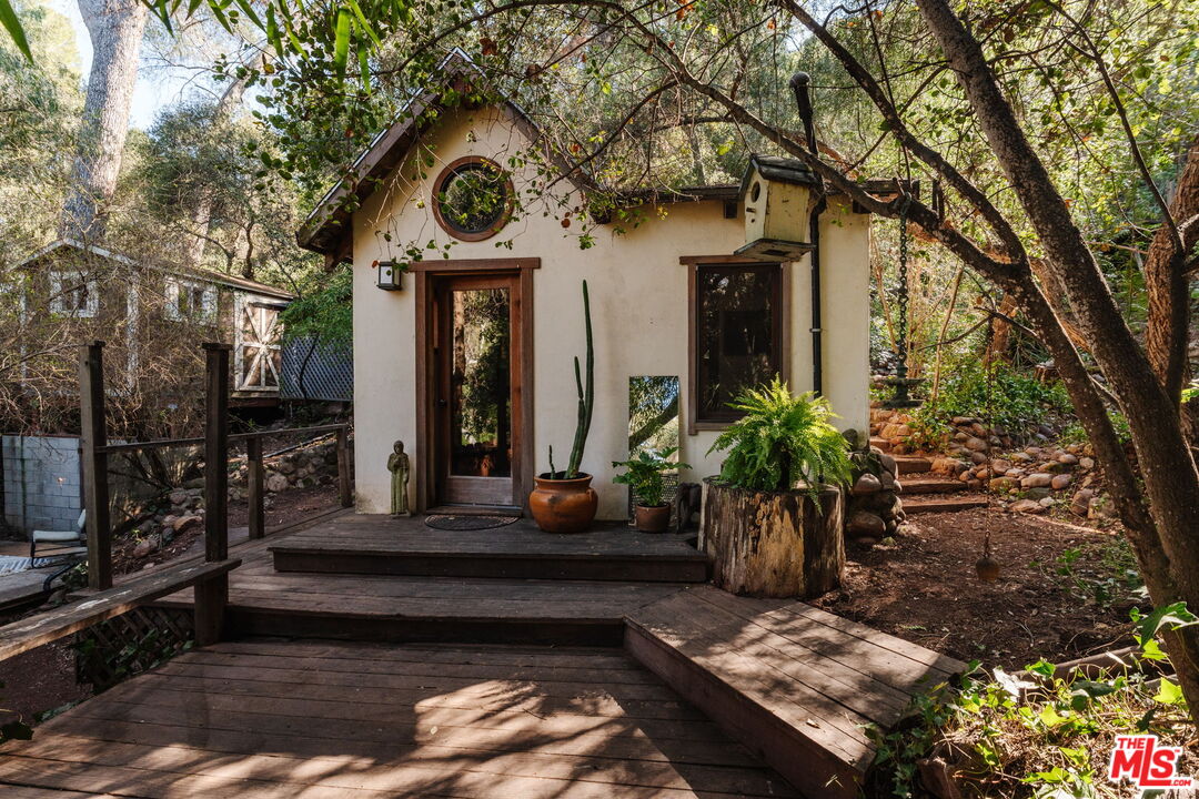 23300 Red Rock Road Topanga, CA 90290 - Photo 26 of 59 a view of a house with a small yard and potted plants