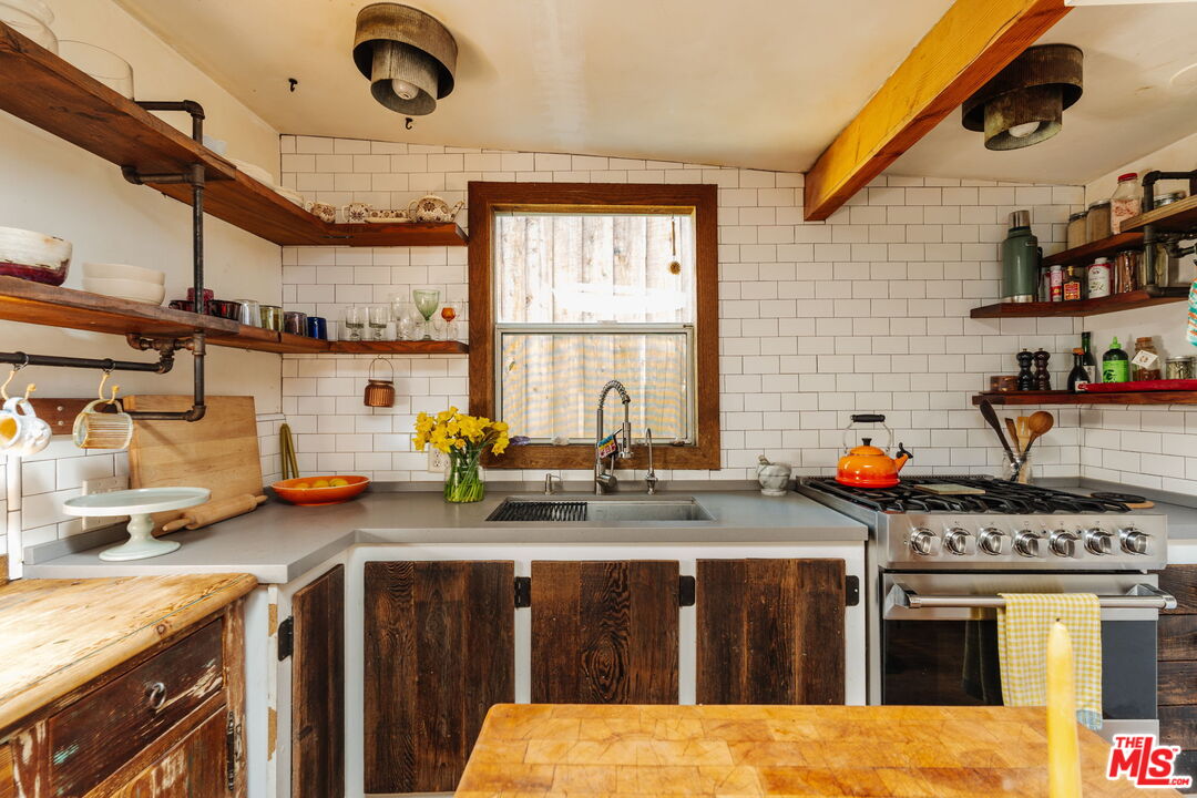 23300 Red Rock Road Topanga, CA 90290 - Photo 7 of 59 a kitchen with a stove and a white wooden cabinets