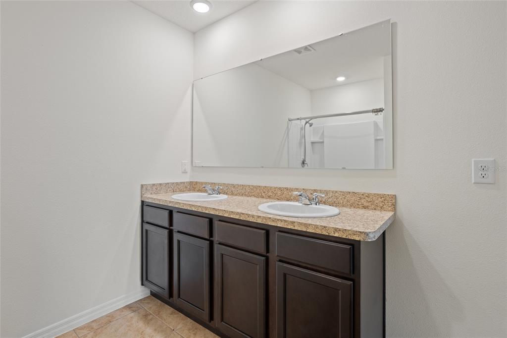 2143 Kalin Way Tavares, FL 32778 - Photo 30 of 37 a bathroom with a granite countertop sink and a mirror