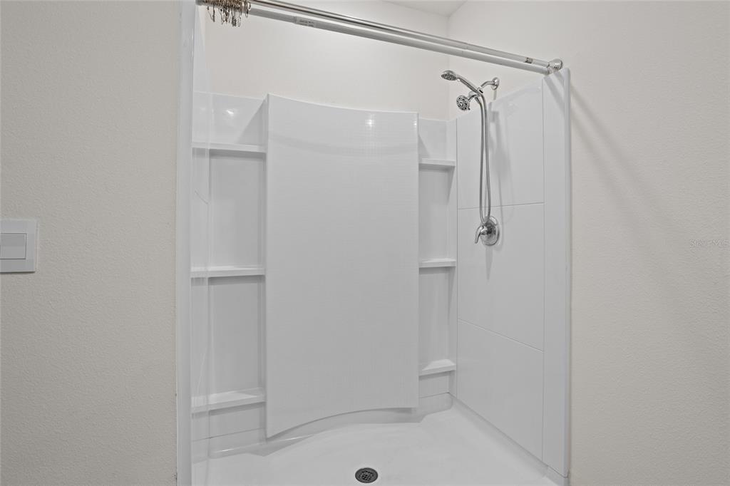 2143 Kalin Way Tavares, FL 32778 - Photo 31 of 37 a bathroom with a shower and a glass door