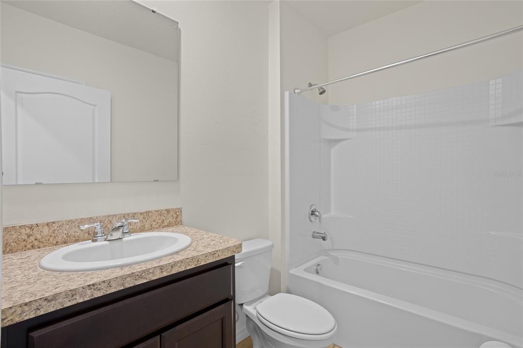 2143 Kalin Way Tavares, FL 32778 - Photo 10 of 37 a bathroom with a granite countertop sink toilet and shower