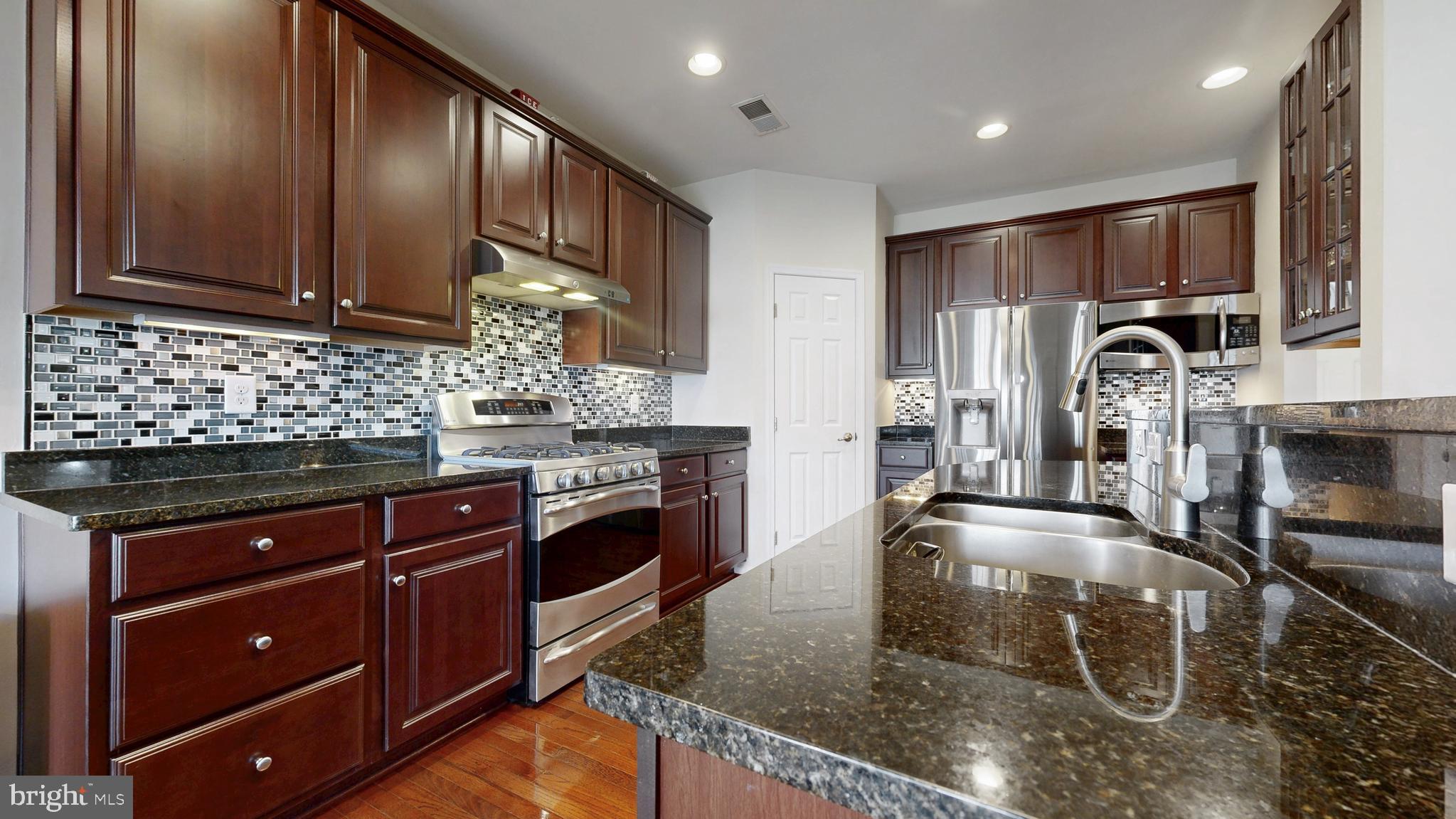 546 Stonehaven Drive Townsend, DE 19734 - Photo 11 of 60 a kitchen with stainless steel appliances granite countertop a sink stove and cabinets