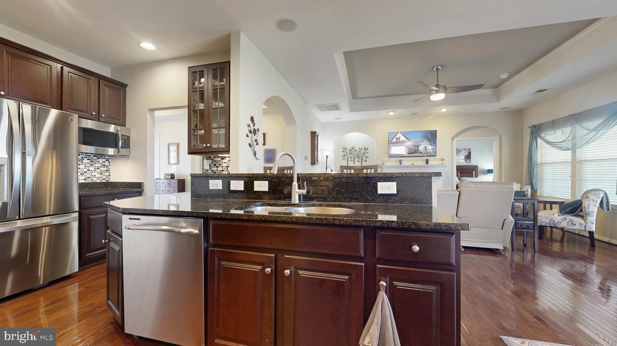546 Stonehaven Drive Townsend, DE 19734 - Photo 12 of 60 a kitchen with stainless steel appliances granite countertop a refrigerator a sink dishwasher a stove and a dining table with wooden floor