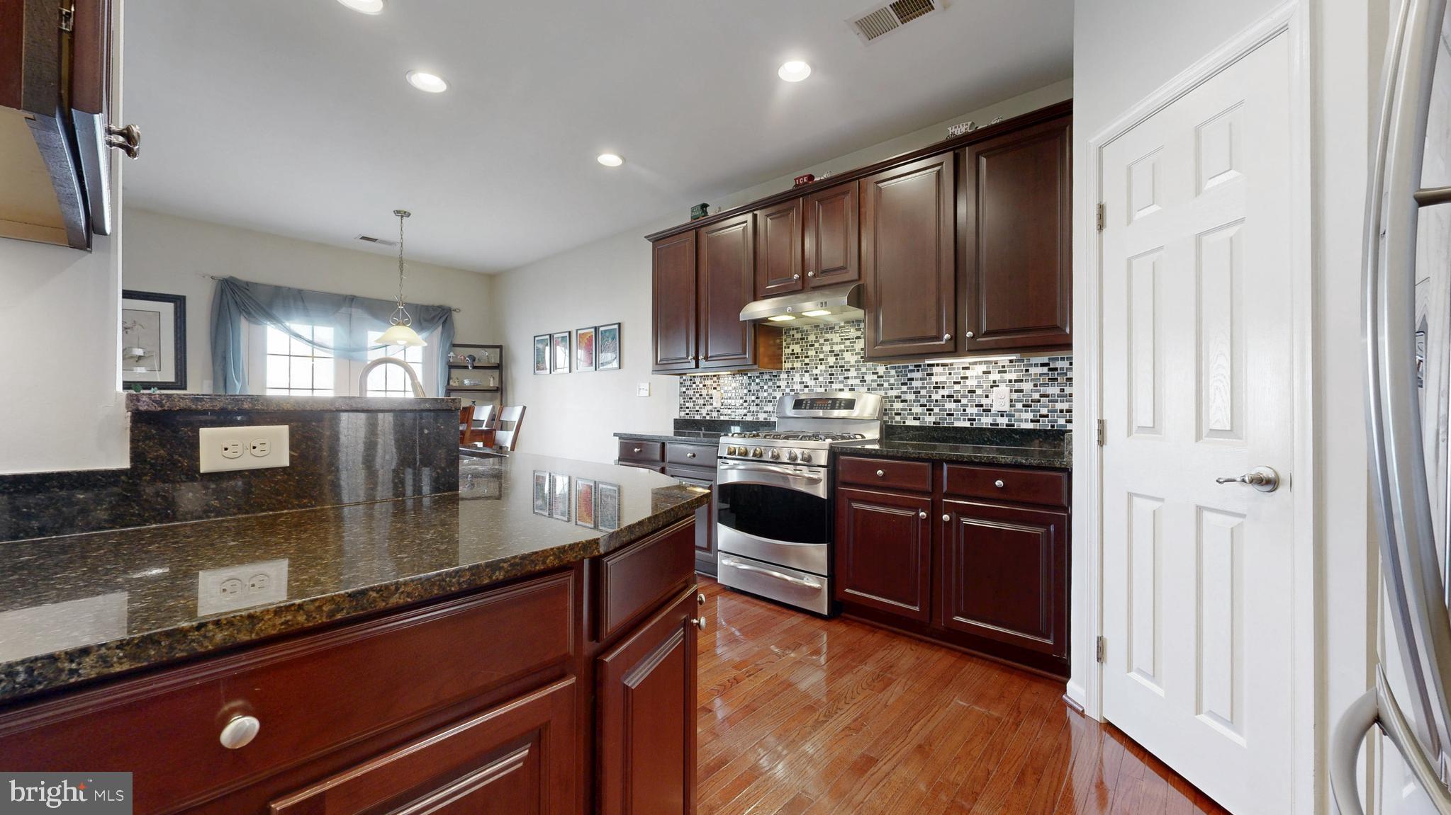 546 Stonehaven Drive Townsend, DE 19734 - Photo 10 of 60 a kitchen with stainless steel appliances granite countertop a sink stove and refrigerator