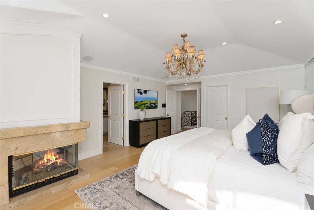 74 Chandon Newport Coast, CA 92657 - Photo 13 of 27 a spacious bedroom with a bed and a fireplace