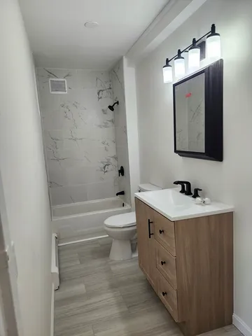 a bathroom with a toilet sink and mirror