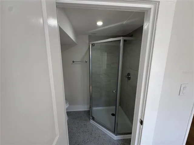 a bathroom with a shower and a glass door
