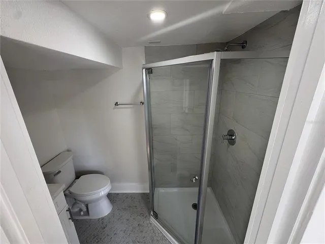 a white toilet sitting next to a shower
