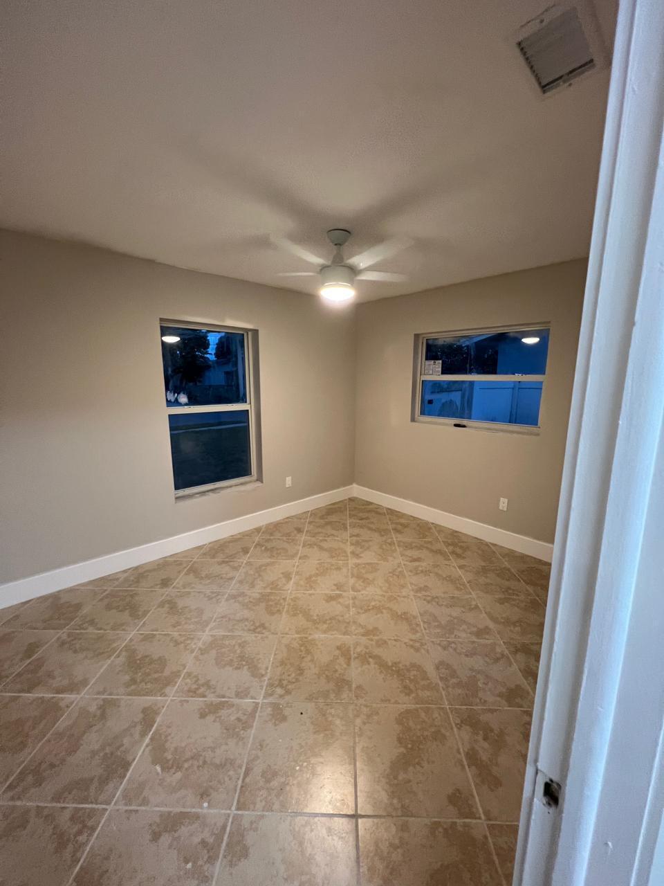9675 Southwest 1st Place Boca Raton, FL 33428 - Photo 7 of 11 en empty room with windows and fireplace