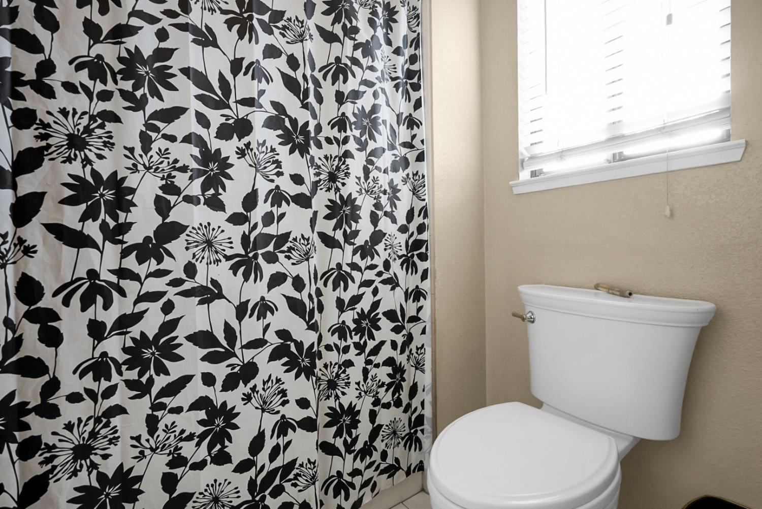 2809 Fleming Court Modesto, CA 95356 - Photo 23 of 34 a white toilet sitting next to a shower curtain