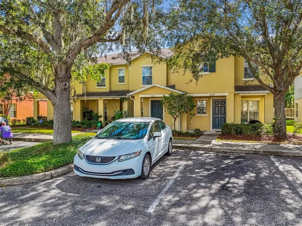 a front view of a house with a garden and trees