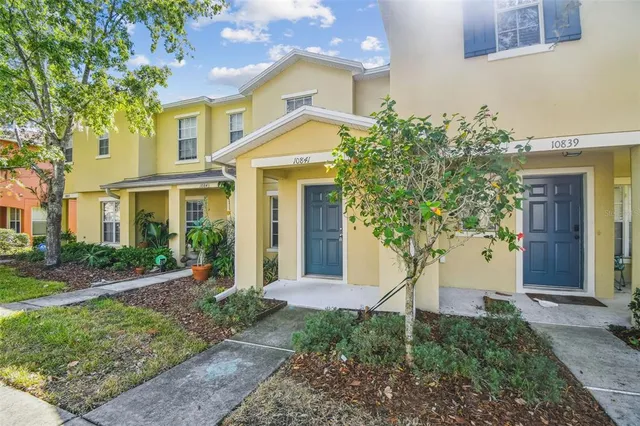 a front view of a house with a yard and trees
