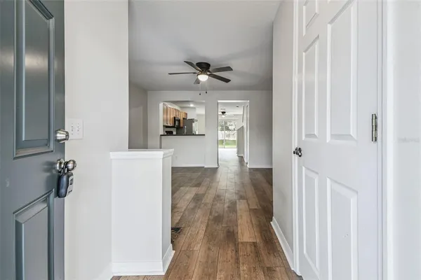 a view of a hallway with a dining table chairs