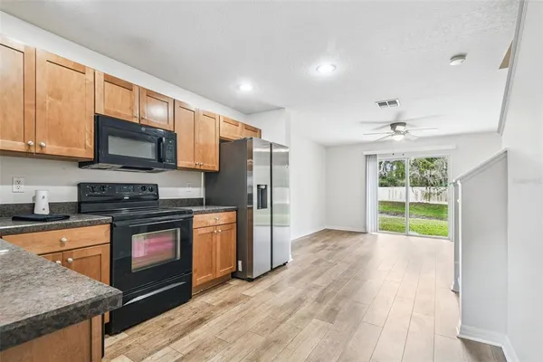 a kitchen with stainless steel appliances granite countertop a stove a sink and a microwave