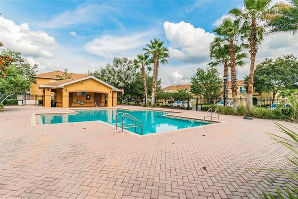 a front view of a house with a garden and a tree