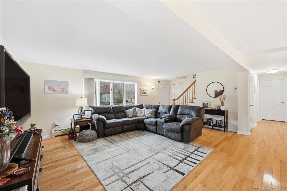 198 Dartmouth Drive Groton, CT 06355 - Photo 5 of 25 a living room with furniture a flat screen tv and a fireplace