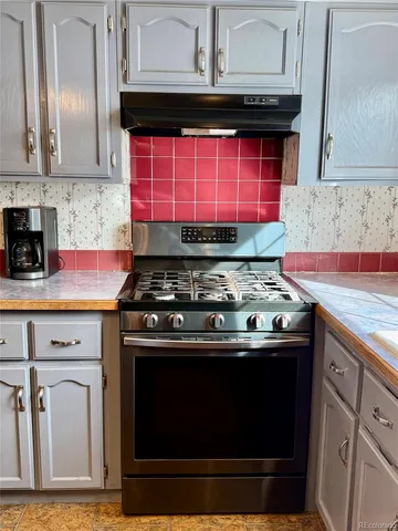 a stove top oven sitting inside of a kitchen