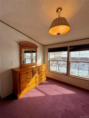 an empty room with windows and ceiling fan