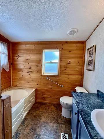 a bathroom with a granite countertop sink a toilet and bathtub