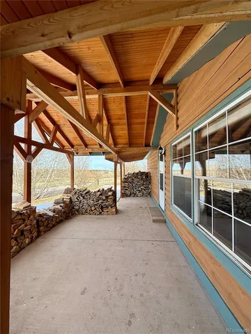 a view of a dry yard with trees in the background