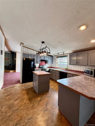 a kitchen with stainless steel appliances kitchen island granite countertop a refrigerator and a sink