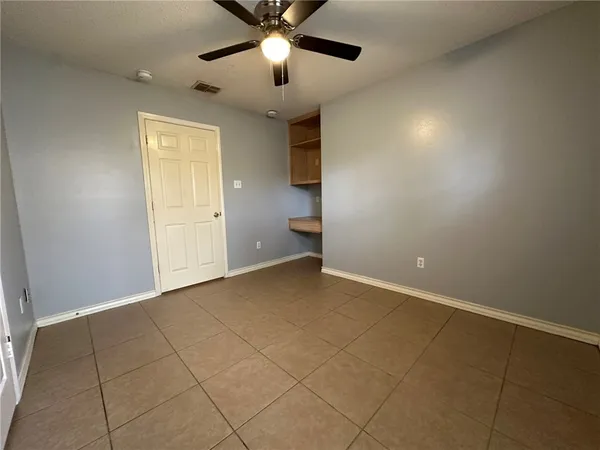 an empty room with a ceiling fan and a window