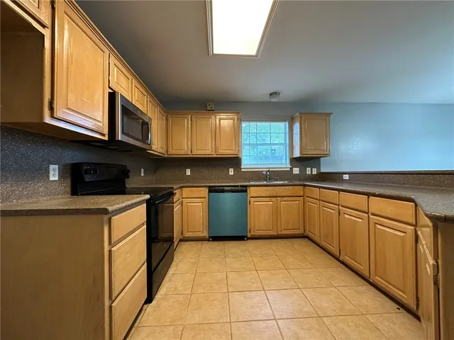 a kitchen with stainless steel appliances granite countertop a stove a sink dishwasher and a microwave oven on the blue kitchen countertops