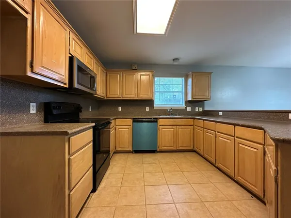a kitchen with stainless steel appliances granite countertop a stove a sink dishwasher and a microwave oven on the blue kitchen countertops