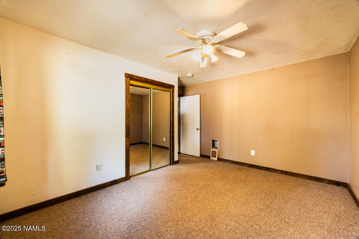 129 North Spitz Spring Road Parks, AZ 86018 - Photo 25 of 59 an empty room with a ceiling fan and a window