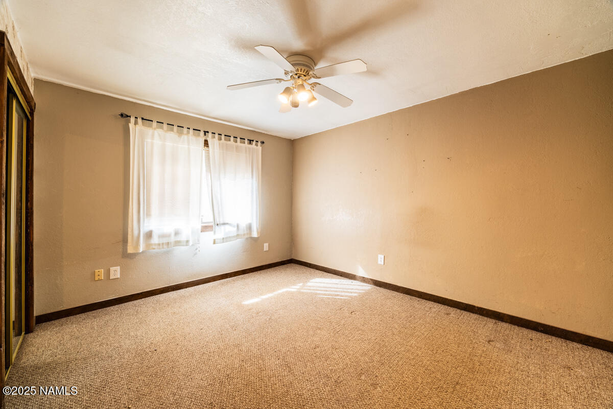 129 North Spitz Spring Road Parks, AZ 86018 - Photo 26 of 59 an empty room with a ceiling fan and window