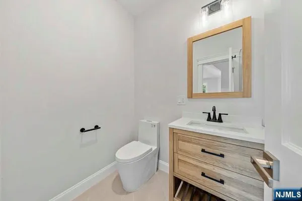 a bathroom with a toilet sink vanity and mirror