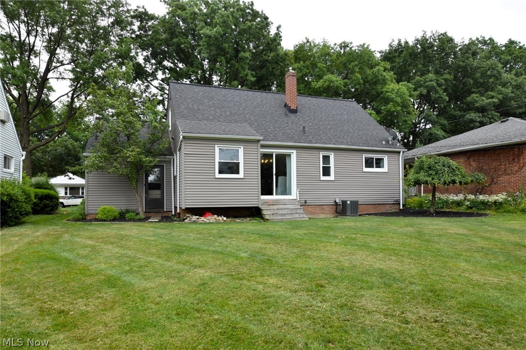 1174 Haverston Road Cleveland, OH 44124 - Photo 20 of 21 Back of house with a lawn and central AC unit