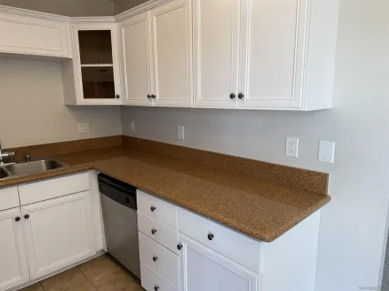 a kitchen with white cabinets and white appliances
