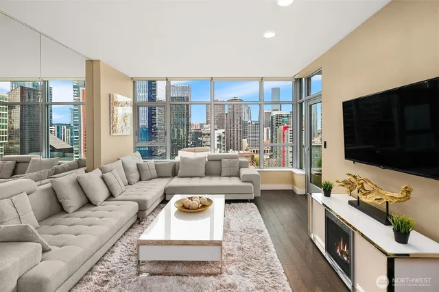 a living room with furniture flat screen tv and a large window