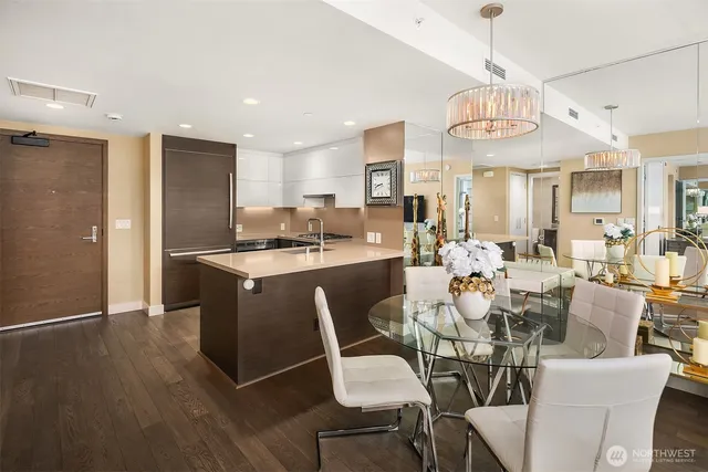 a view of a dining room with furniture a kitchen and chandelier