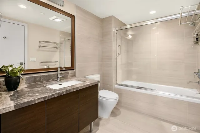 a bathroom with a double vanity sink toilet mirror and shower