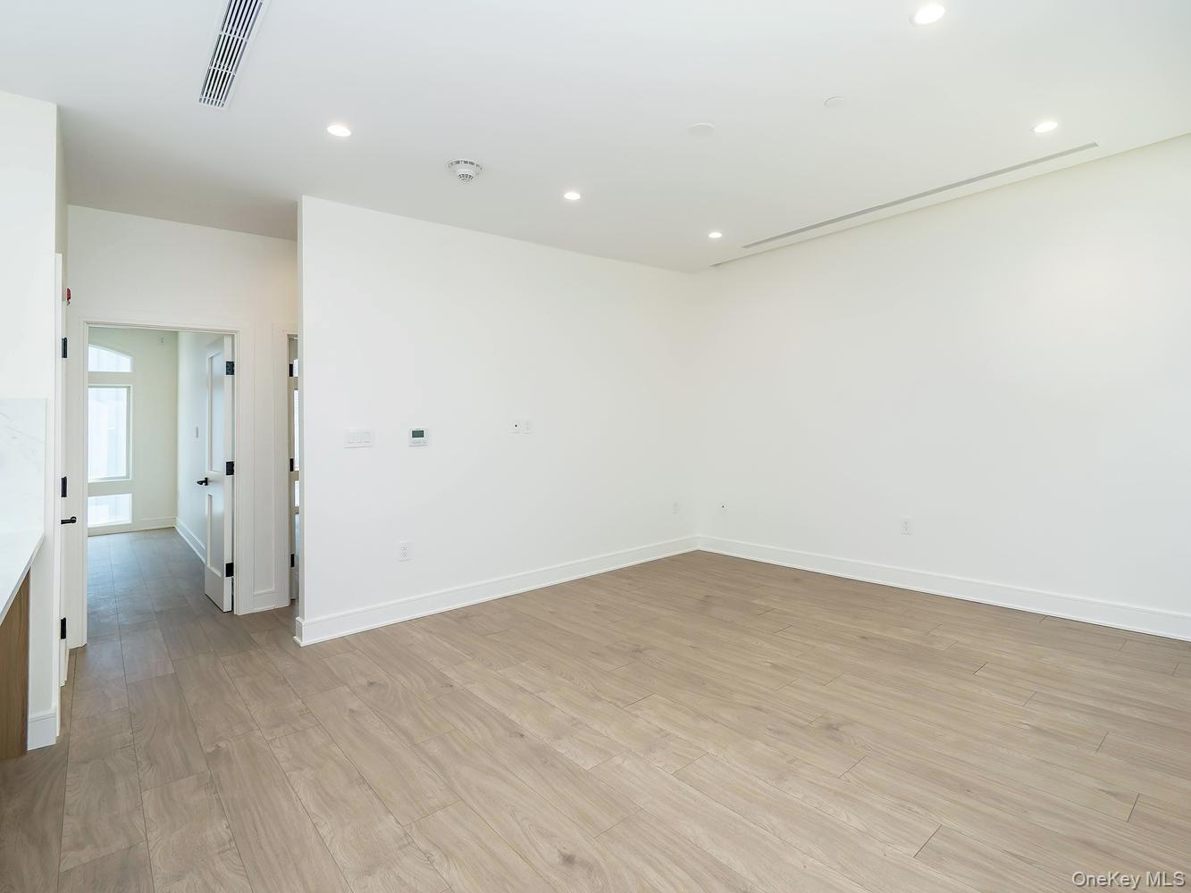 24 Lumber Road, Unit 1 Roslyn, NY 11576 - Photo 8 of 18 wooden floor in an empty room with a window