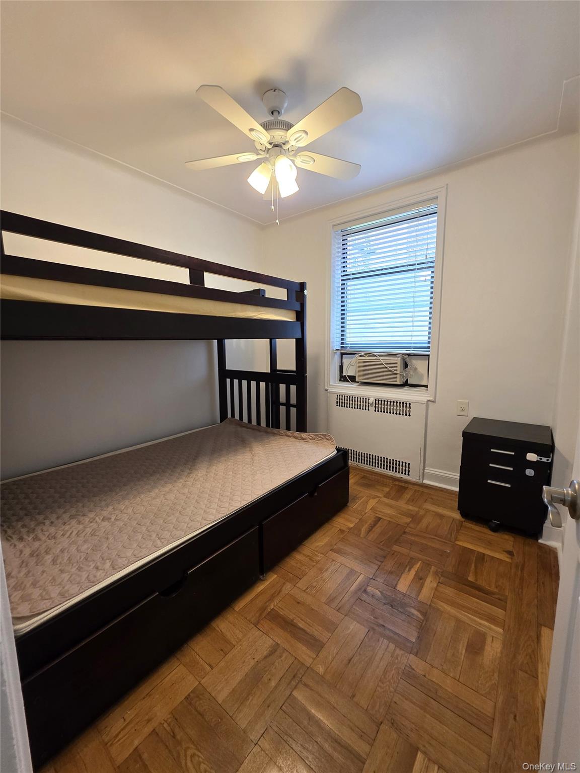 98-50 67th Avenue, Unit 1H Queens, NY 11374 - Photo 11 of 15 a bedroom with a bed and a ceiling fan