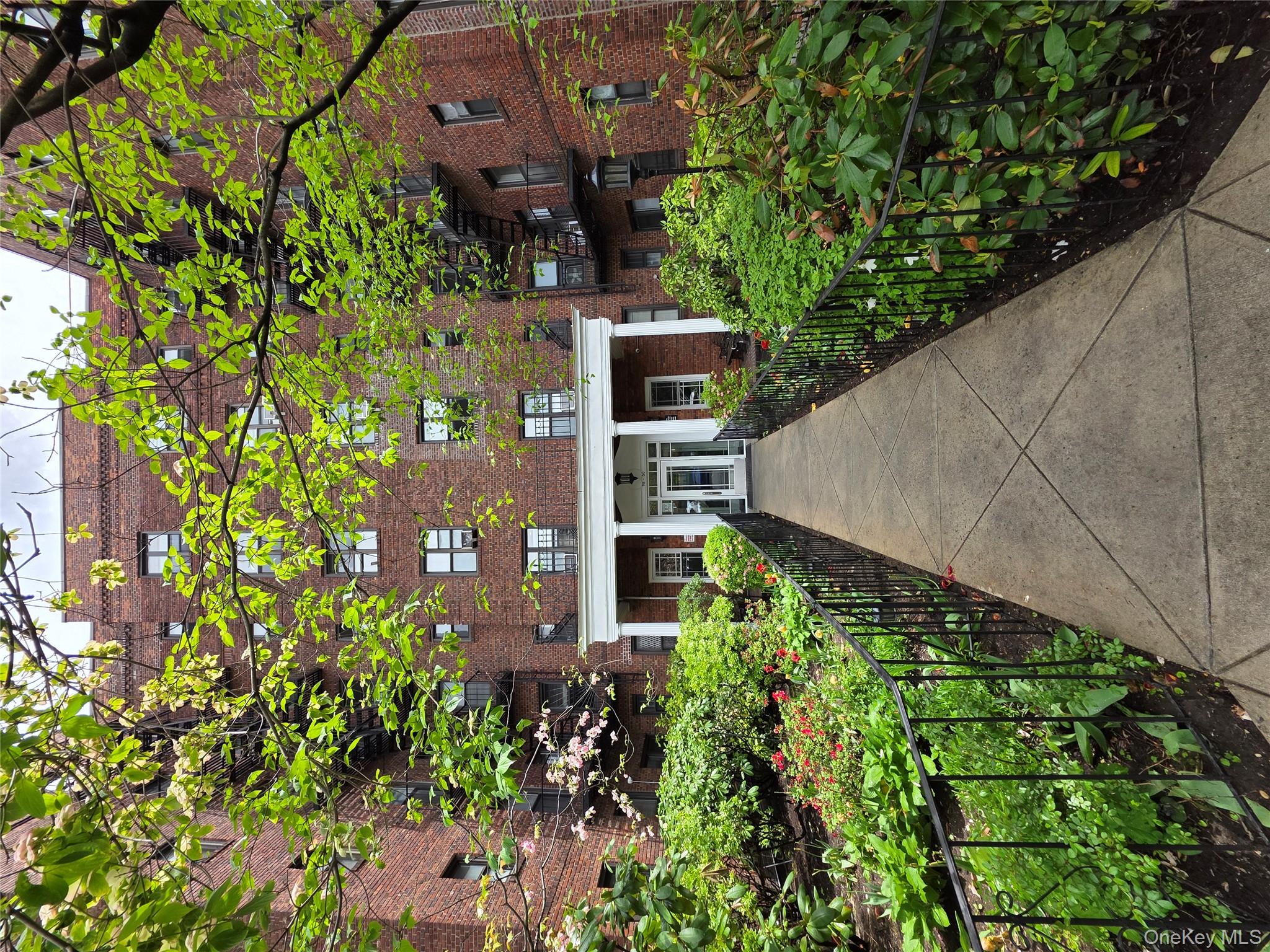 98-50 67th Avenue, Unit 1H Queens, NY 11374 - Photo 13 of 15 a front view of a house with a yard