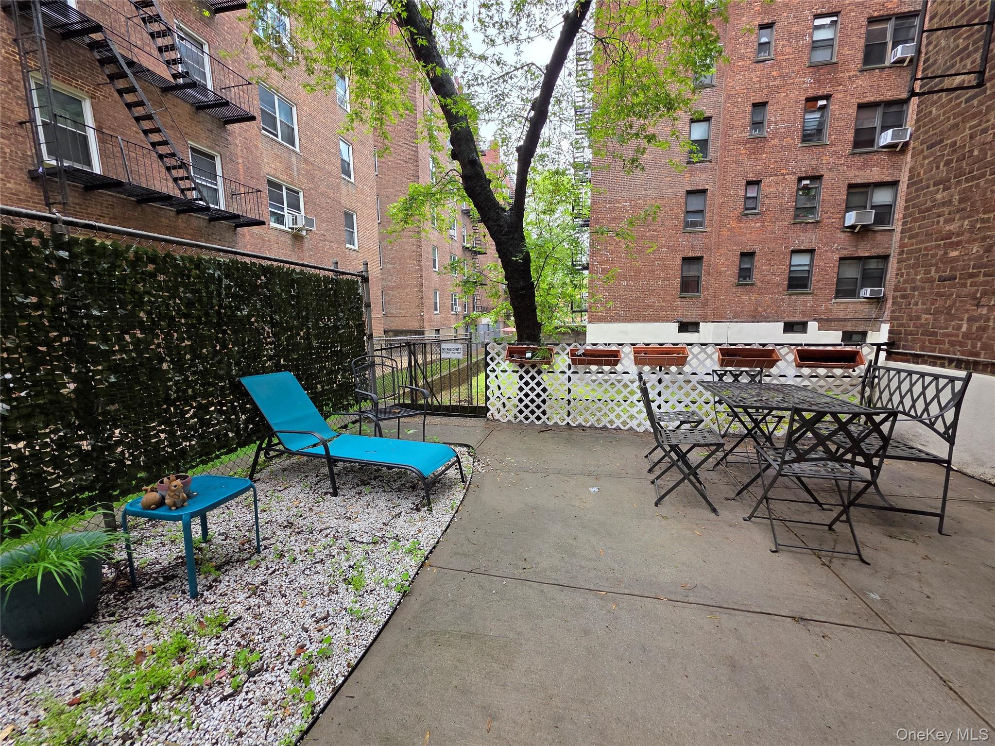 98-50 67th Avenue, Unit 1H Queens, NY 11374 - Photo 15 of 15 a view of a patio with table and chairs and potted plants