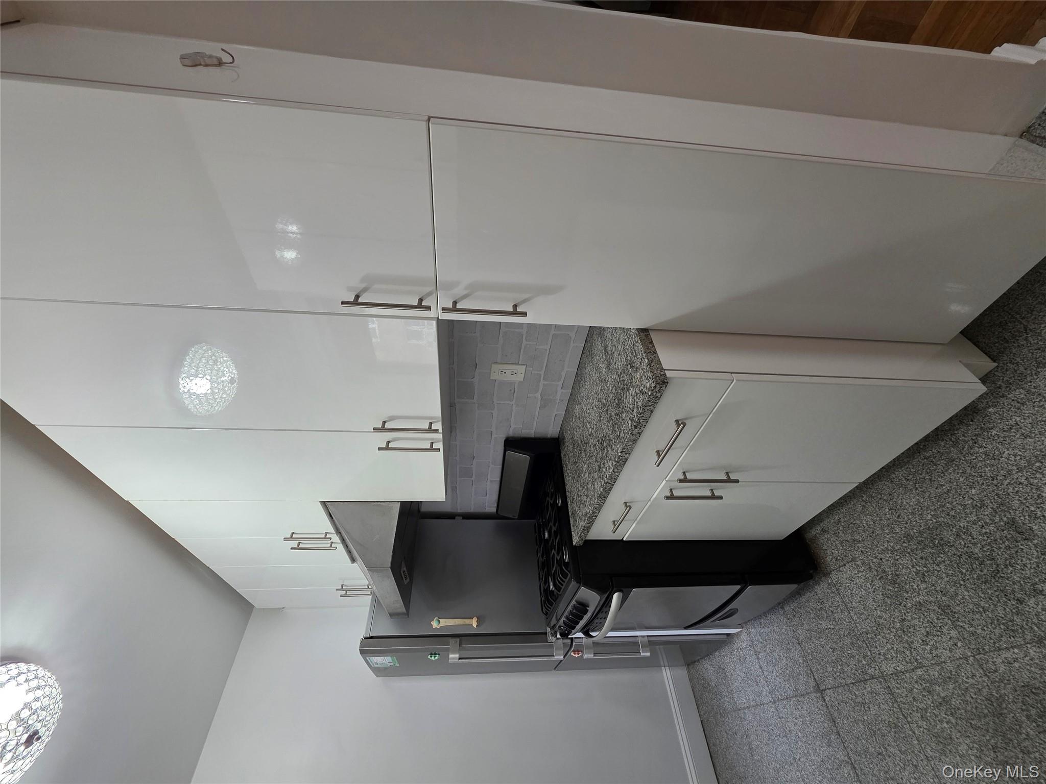 98-50 67th Avenue, Unit 1H Queens, NY 11374 - Photo 5 of 15 a kitchen with a refrigerator and a stove top oven