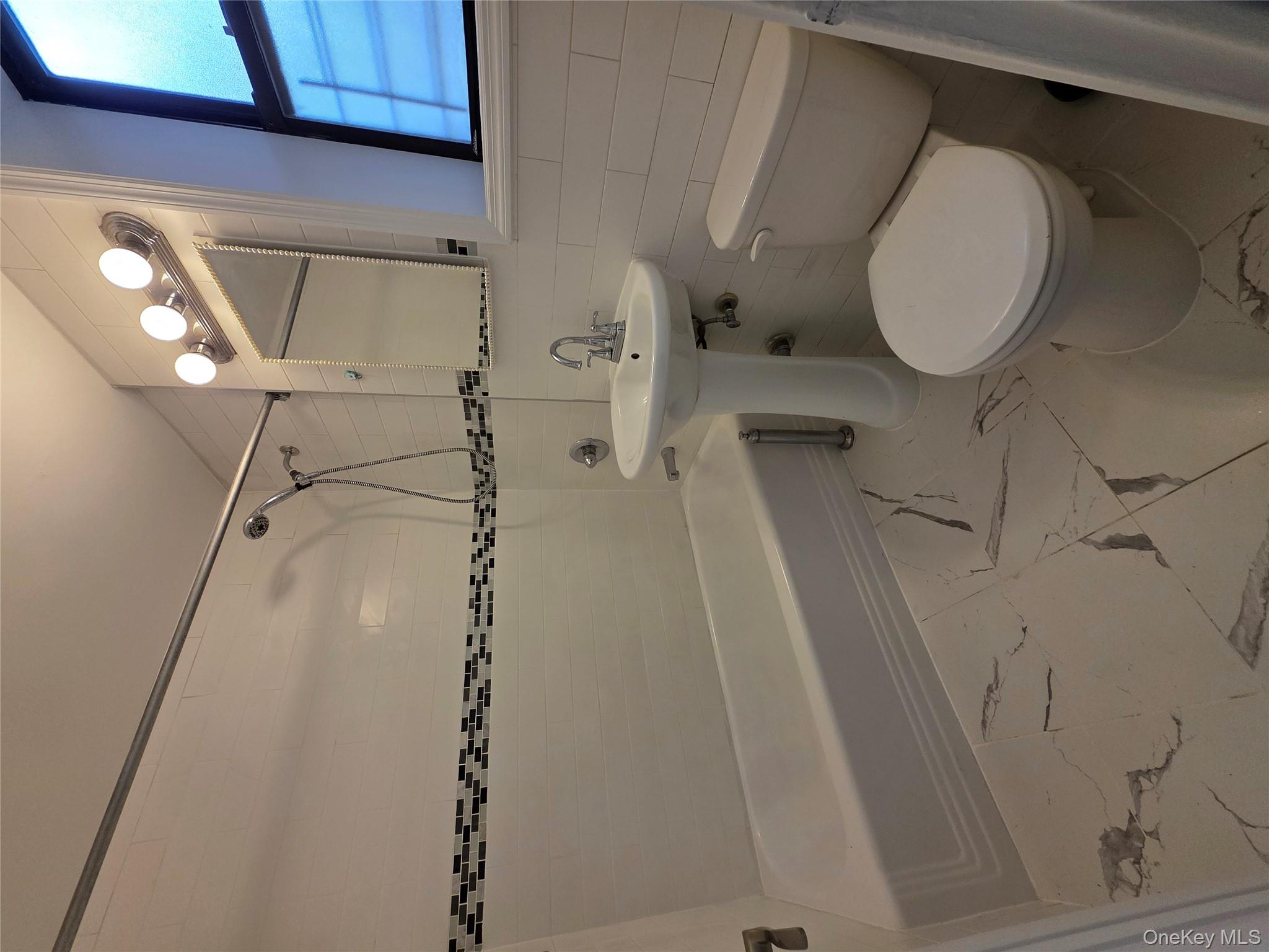 98-50 67th Avenue, Unit 1H Queens, NY 11374 - Photo 10 of 15 a bathroom with a sink a toilet and a mirror