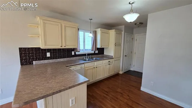 a kitchen with stainless steel appliances granite countertop a sink a stove and a wooden floor