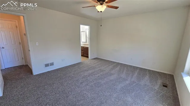 an empty room with a ceiling fan and window