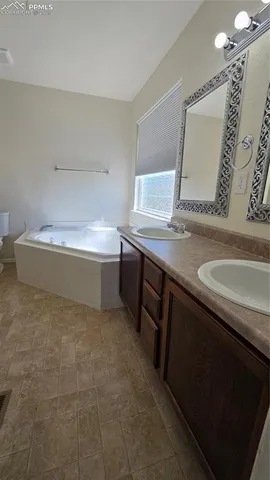 a bathroom with a granite countertop sink a toilet and mirror