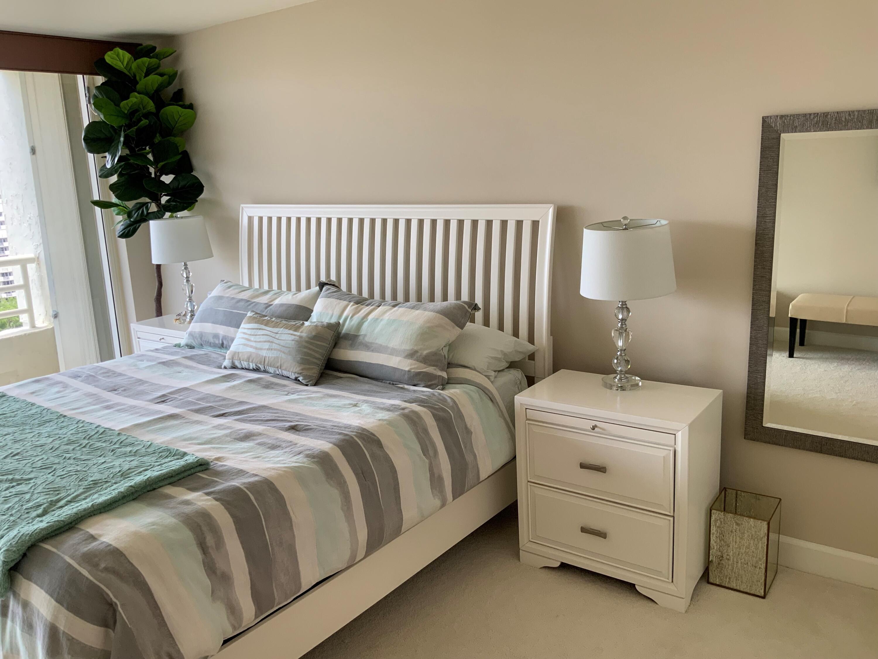 4201 North Ocean Boulevard, Unit 1705 Boca Raton, FL 33431 - Photo 18 of 37 a bedroom with a bed and a lamp