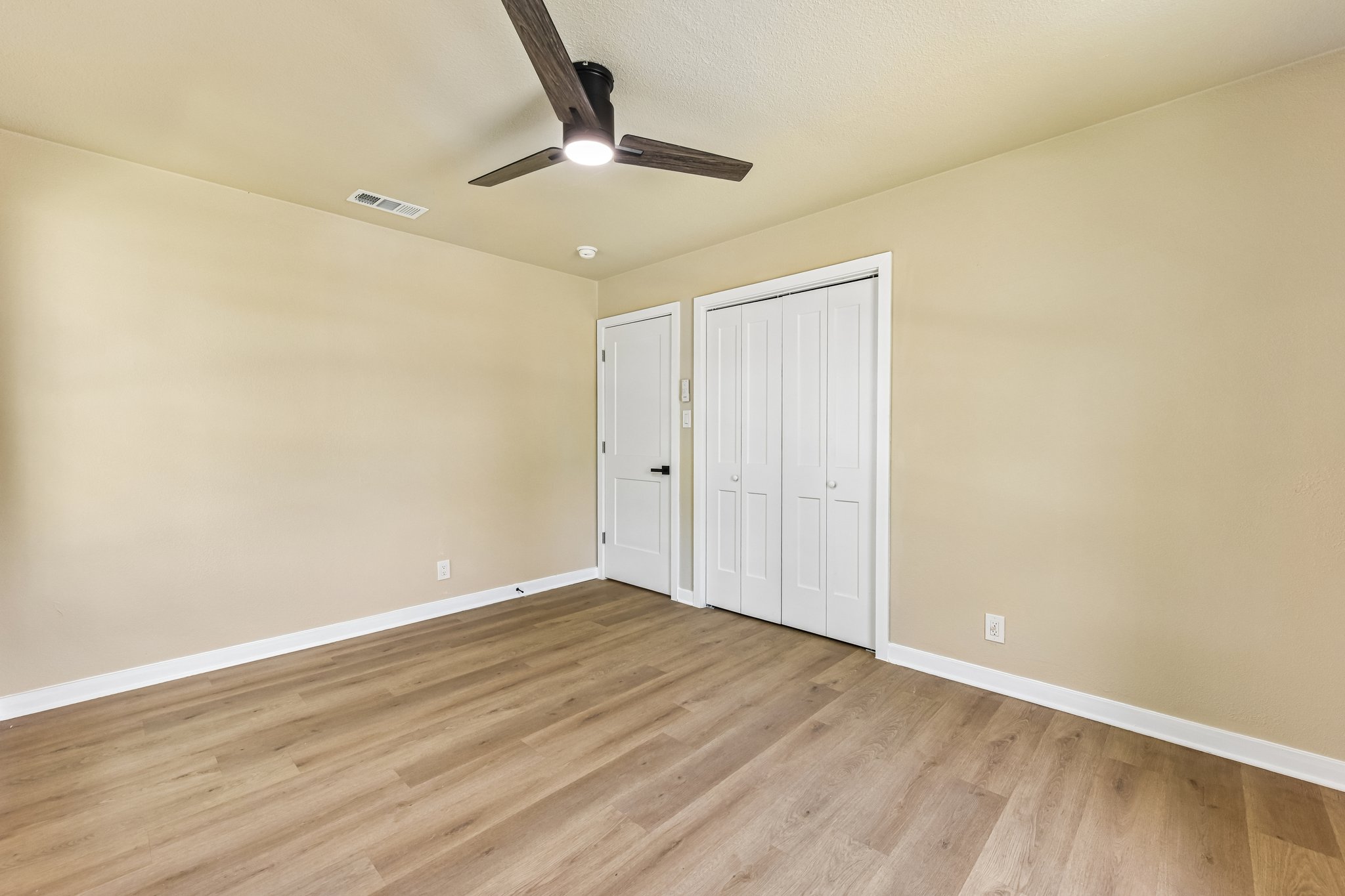 7523 Glenhill Road Austin, TX 78752 - Photo 14 of 38 A well-lit bedroom with modern wood-look flooring and a contemporary ceiling fan offers a comfortable retreat.