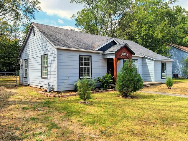 a front view of house with yard and trees around