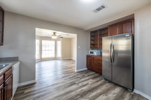 a kitchen with stainless steel appliances granite countertop wooden cabinets and a stove top oven